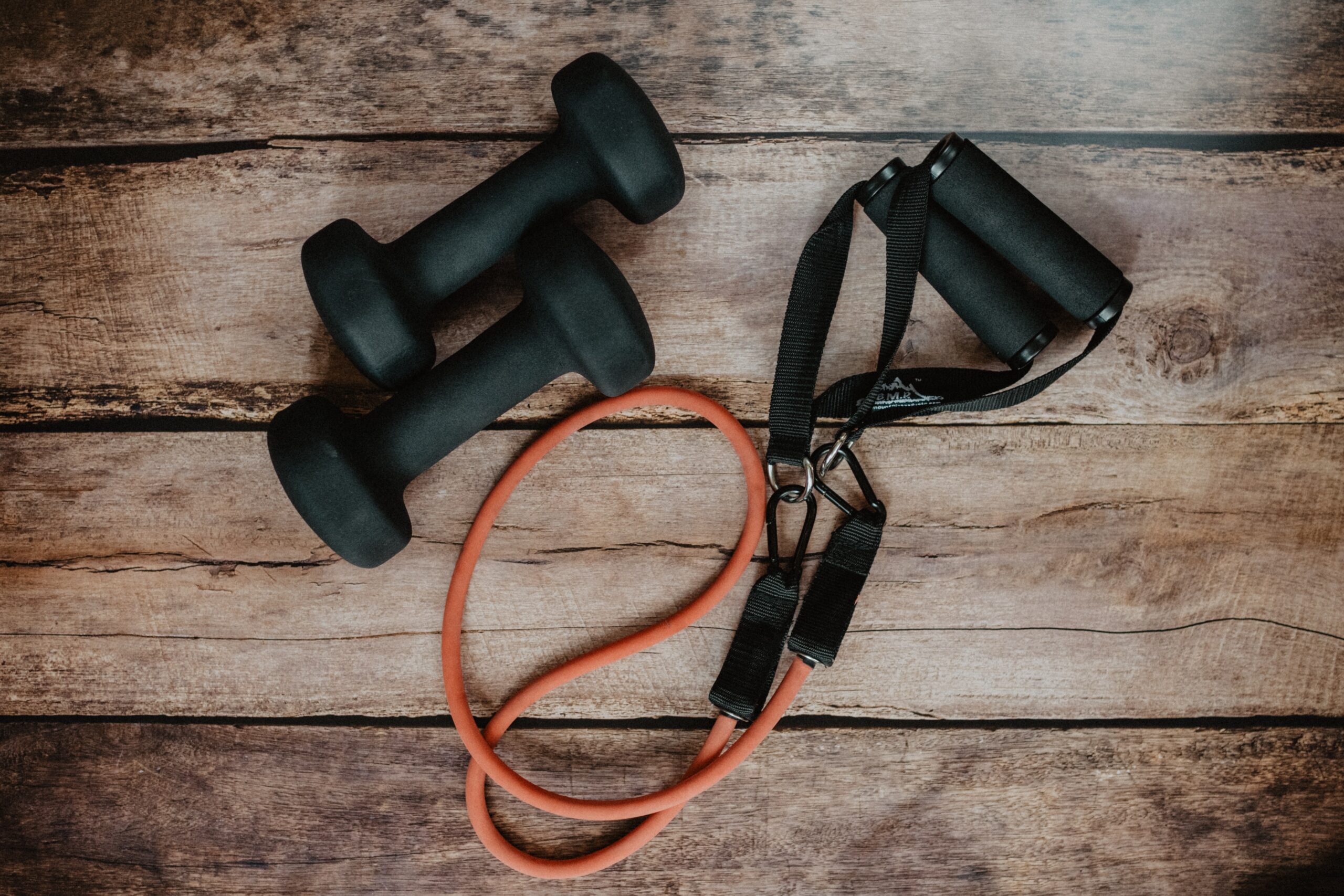 two black dumbbells and a bungee cord resistance band 